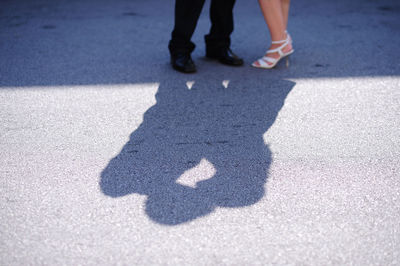 Low section of couple kissing while standing on road