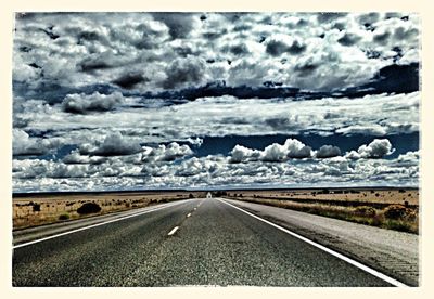 Country road against cloudy sky