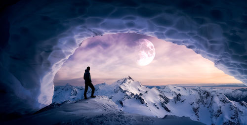 Rear view of man on snowcapped mountain against sky