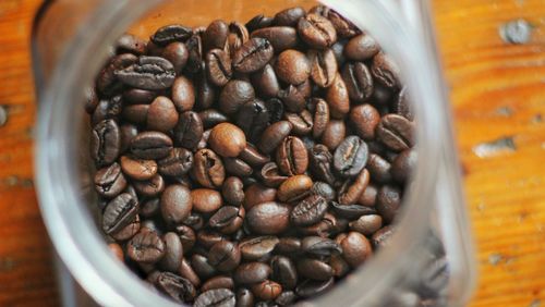 Directly above shot of roasted coffee beans in jar on table