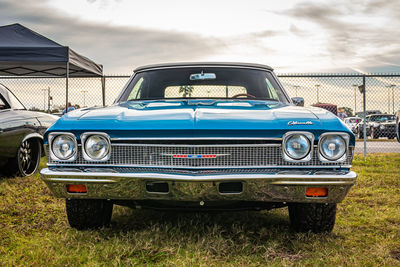 Old vintage car on field against sky