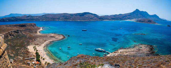 Scenic view of sea and mountains against sky