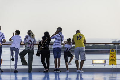 Rear view of people walking against sky