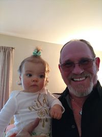 Portrait of happy father and son at home