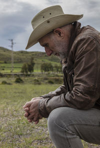 Portrait of adult man in cowboy hat on field