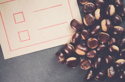 Close-up of chestnuts by paper on slate