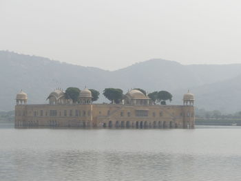 Built structure by lake against sky