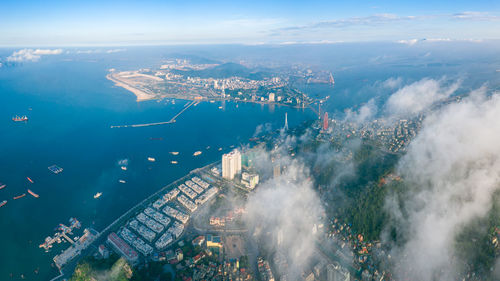 High angle view of buildings by sea against sky