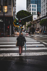 Full length rear view of man walking on road