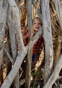 Portrait of smiling girl on tree trunk