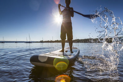 Full length woman paddleboarding in lake