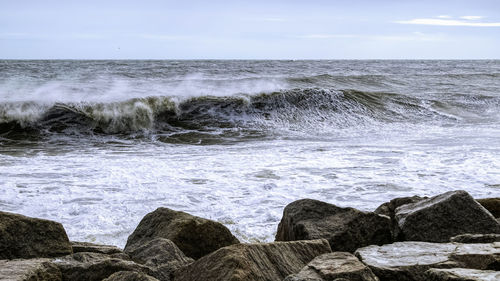 Scenic view of rocks in sea against sky