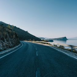 Road by sea against clear sky