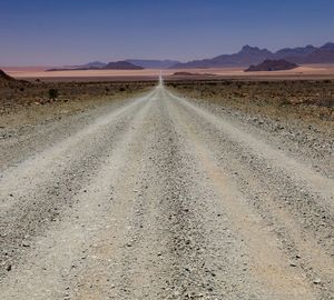 Road amidst desert against sky