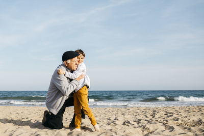 Grandfather and grandson hugging on the beach