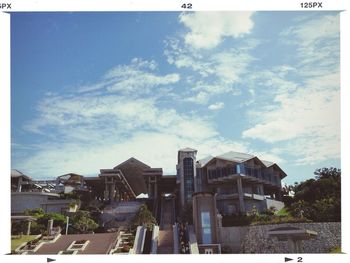 Buildings in city against cloudy sky