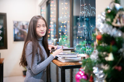 Young woman standing on table at home