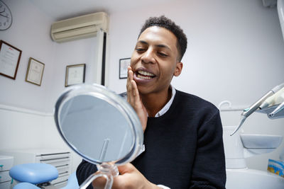 Close-up of man looking at mirror in clinic