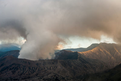 Smoke emitting from volcanic mountain against sky