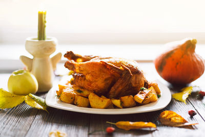 Autumn composition with leaves, ripe pumpkin and thanksgiving turkey on a dark wooden table.