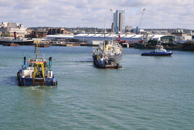 Boats moored at harbor against sky