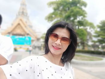 Portrait of woman wearing sunglasses while standing outdoors