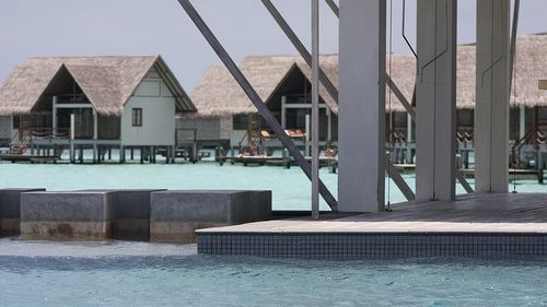 Swimming pool by sea against sky