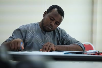 Young man using mobile phone while sitting on table