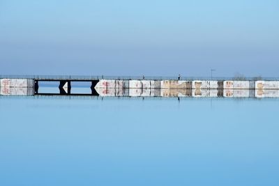 Bridge over river against clear blue sky