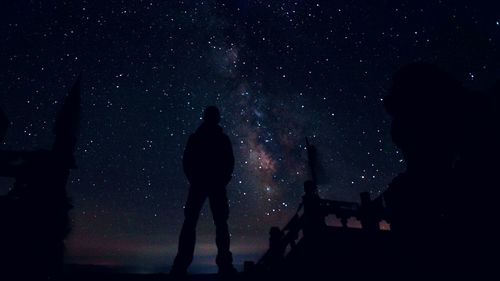 Low angle view of silhouette man standing against sky at night