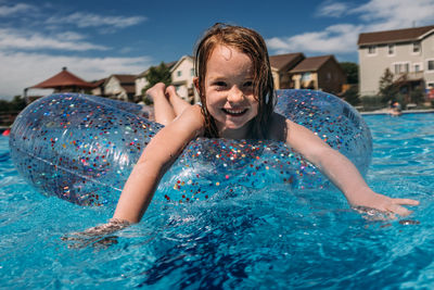 Straight on shot of young girl floating in pool