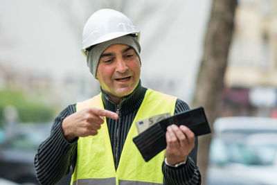 Engineer in reflective clothing looking at wallet