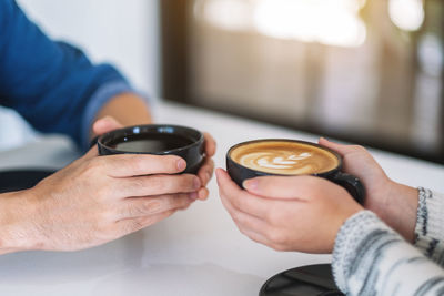 Cropped image of man holding coffee cup