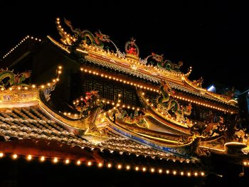 Low angle view of illuminated building against sky at night