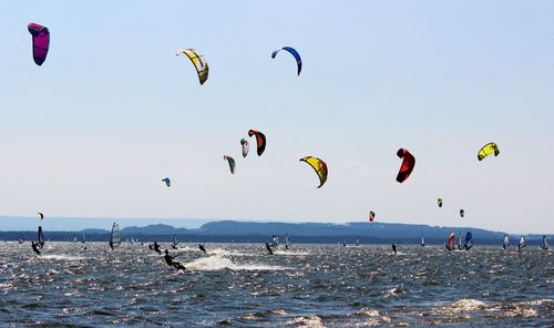 People kiteboarding in sea against sky
