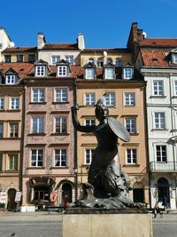 Low angle view of statue against buildings in city