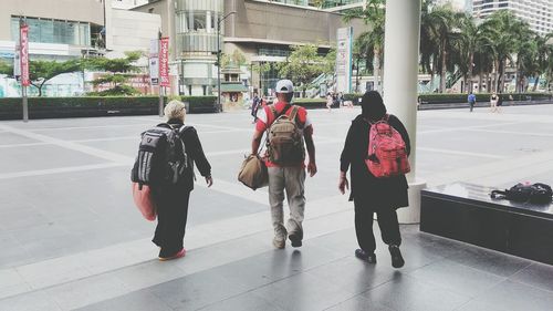 Rear view of people walking on street