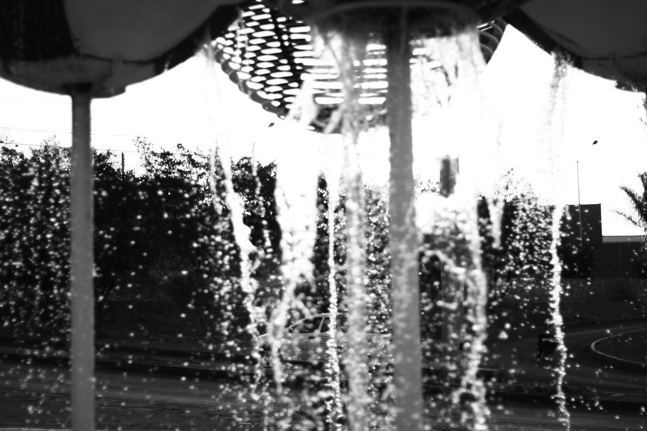 CLOSE-UP OF WET GLASS WINDOW AGAINST SKY