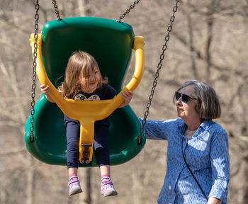 Portrait of happy girl on swing at playground