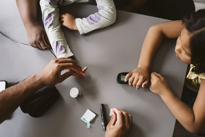 Male doctor doing sugar test of girl in medical clinic