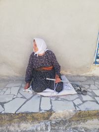 High angle view of woman on footpath against wall