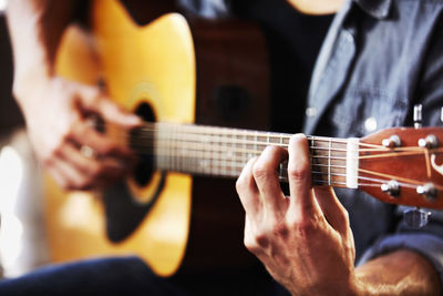 Midsection of man playing guitar