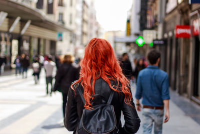 Rear view of people walking on road