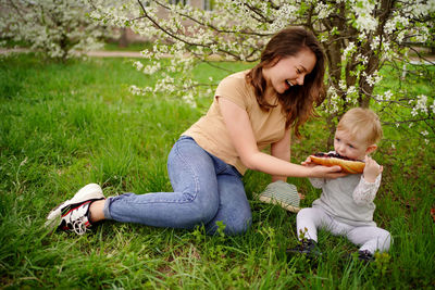 Mother and daughter eat jam bread at a picnic spring