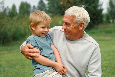 Side view of senior couple sitting on field