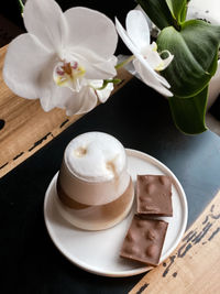 High angle view of coffee and white roses on table