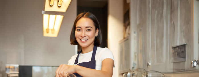 Portrait of young woman standing at home