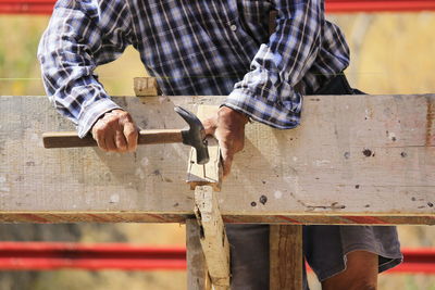 Midsection of carpenter working on wood