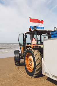 Dutch flag fluttering on tractor at beach