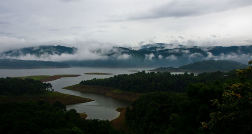 Scenic view of river by mountains against sky